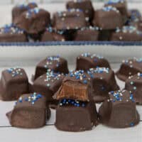 A white surface with chocolate caramel pieces placed all over it.