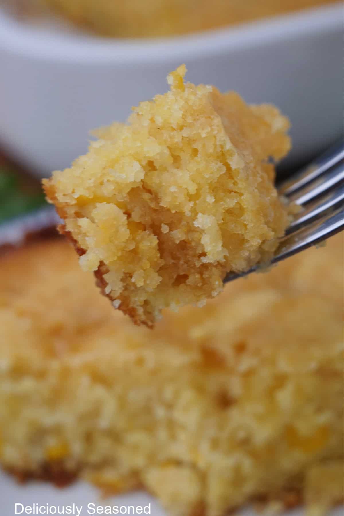 A bite of cornbread souffle on a fork.
