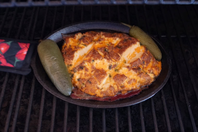 A black oval small cast iron skillet with jalapeno popper smoked cream cheese in it.