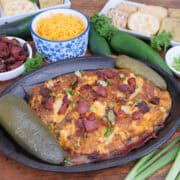 A black oval skillet with smoked jalapeno popper cream cheese in it after being smoked.