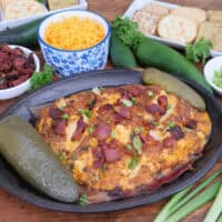 A black oval skillet with smoked jalapeno popper cream cheese in it after being smoked.