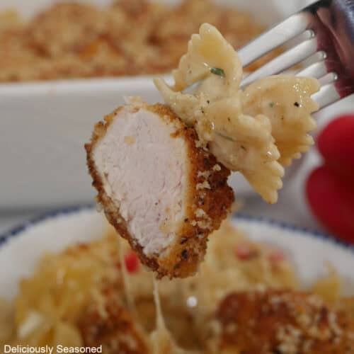 A bite of fried parmesan crusted chicken and pasta on a fork.