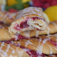 A couple raspberry twists stacked on top of each other with a bite out of the top twists.