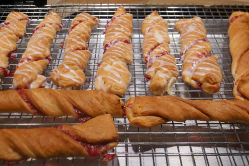 A wire rack with baked raspberry twists on it.