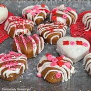 A silver surface with decorated heart-shaped caramels on it.