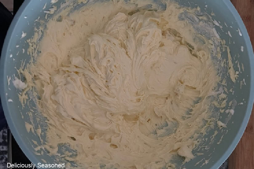 A light blue bowl with the banana pudding mixture in it.
