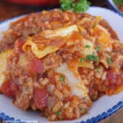 A white bowl with blue time filled with a serving of unstuffed cabbage roll.