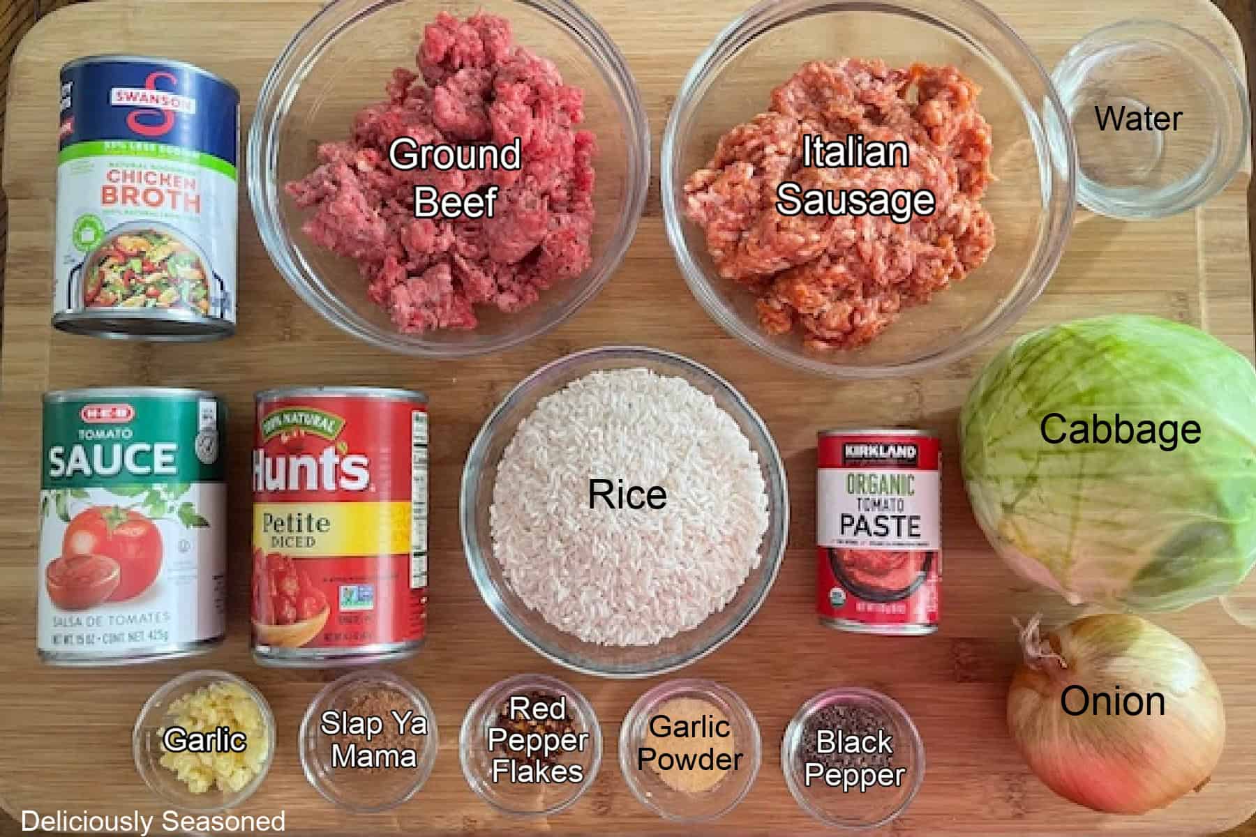 A wood surface with all the ingredients on it to make unstuffed cabbage roll bowls.
