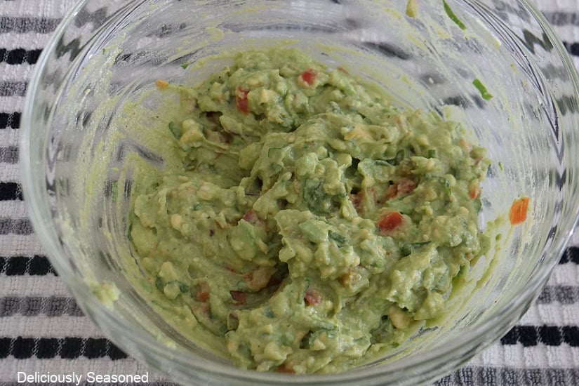 A glass bowl with homemade guacamole in it.