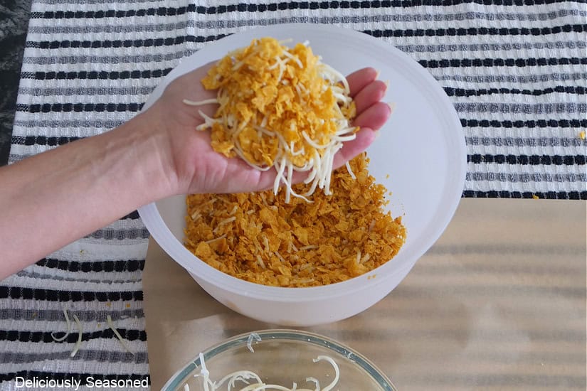 A handful of crushed Doritos and shredded Monterey Jack cheese.