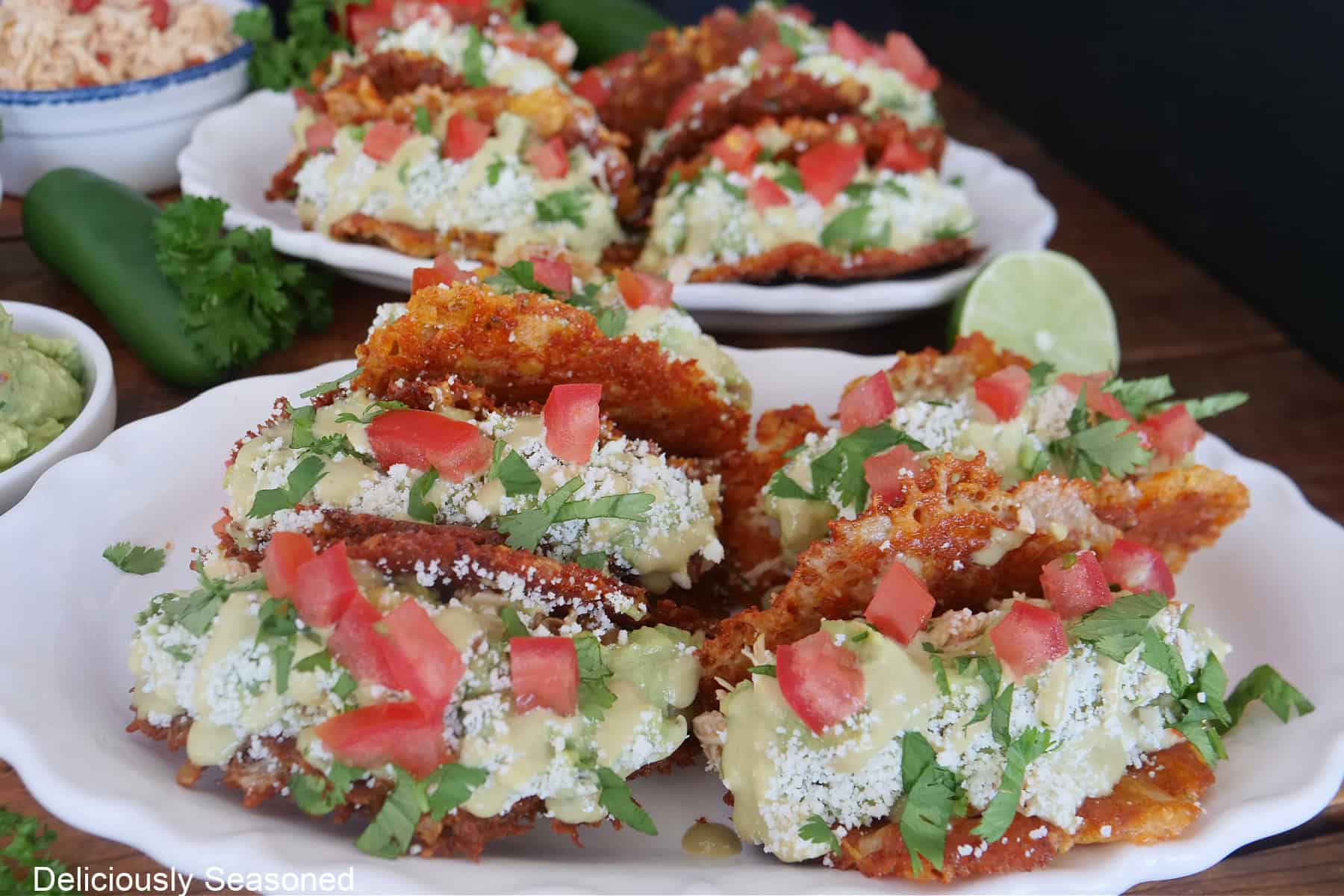Two white plates with crunchy Doritos chicken tacos on them.