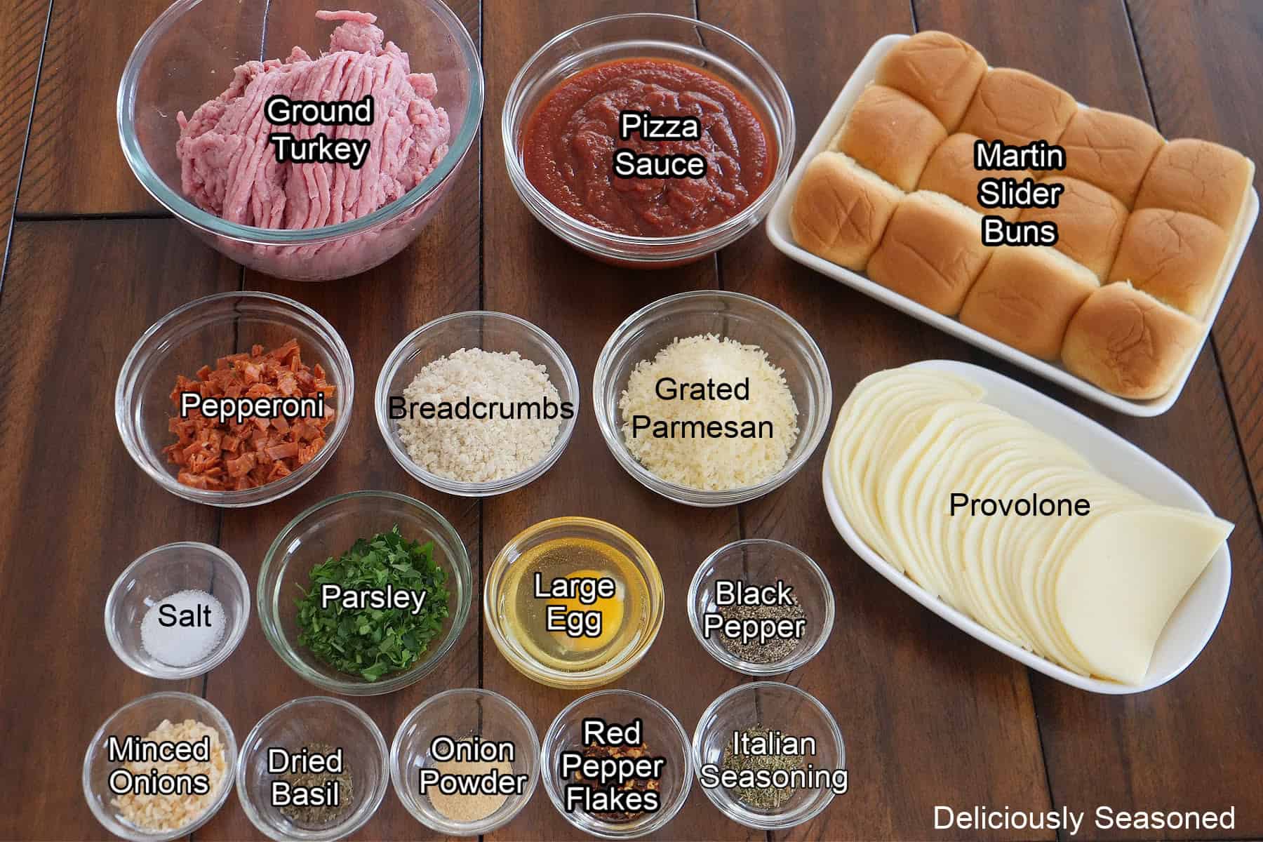 A wood table with all the ingredients needed to make turkey meatball sliders on it.