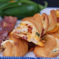 A white plate with three jalapeno popper crescent twists on it.