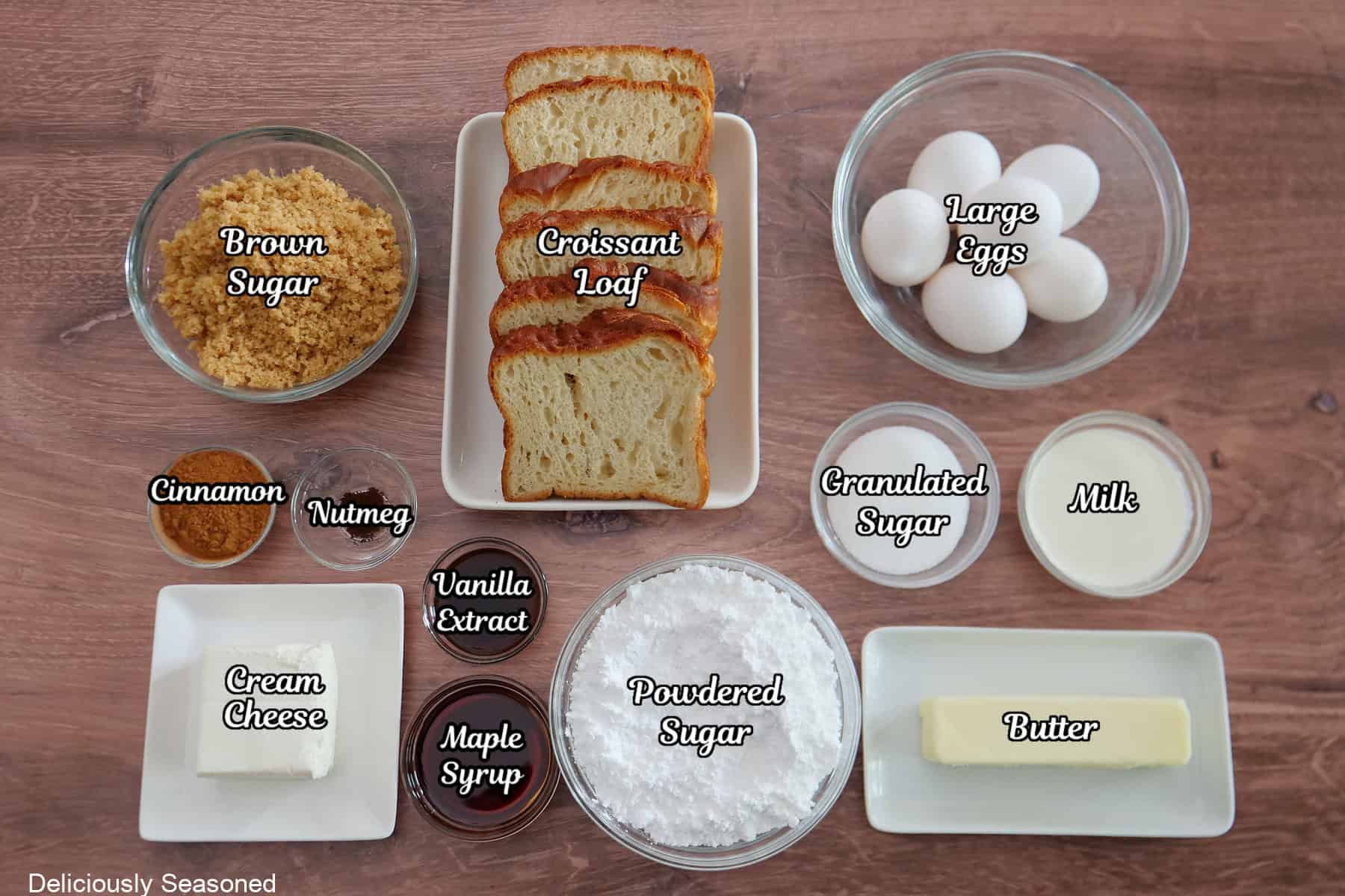 A wood surface with all the ingredients place on it to make cinnamon roll croissant French toast.
