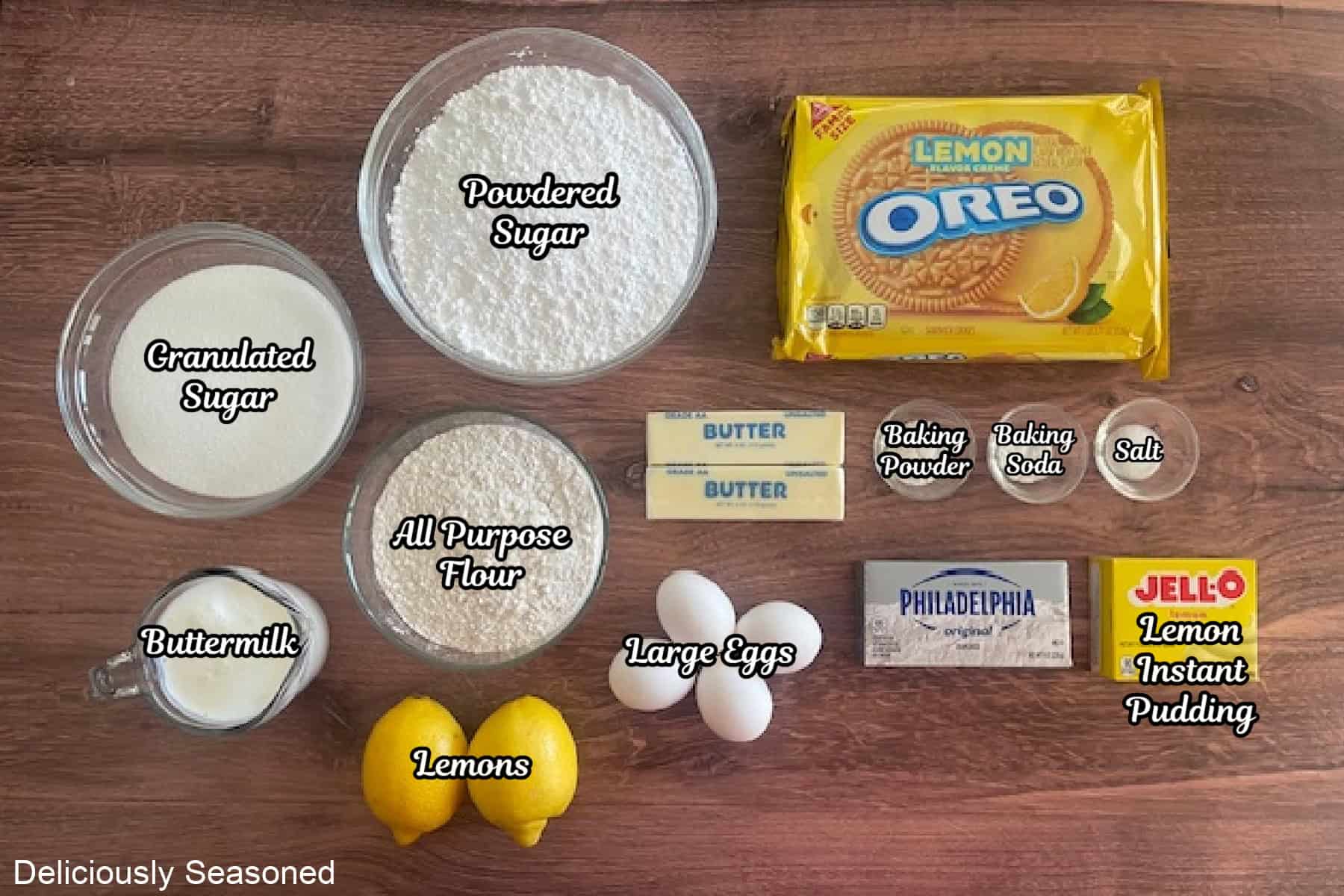 A wood surface with all the ingredients on it to make lemon crunch layer cake.