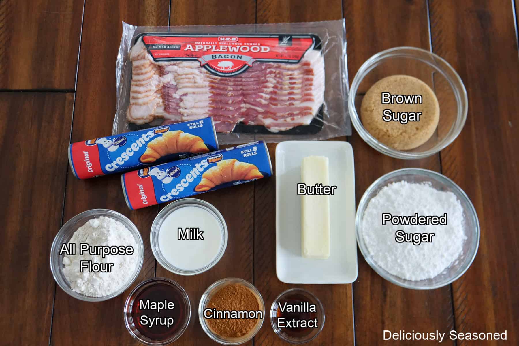 A wood surface with all the ingredients on it to make maple bacon twists with maple icing.