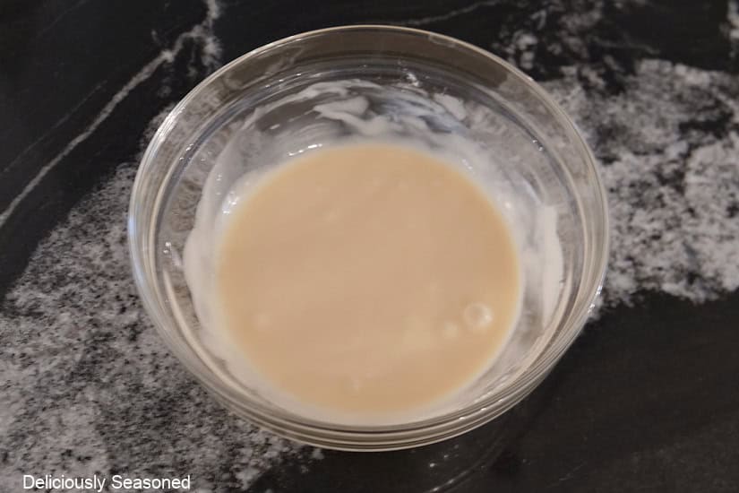 A glass bowl with the maple icing all mixed together.