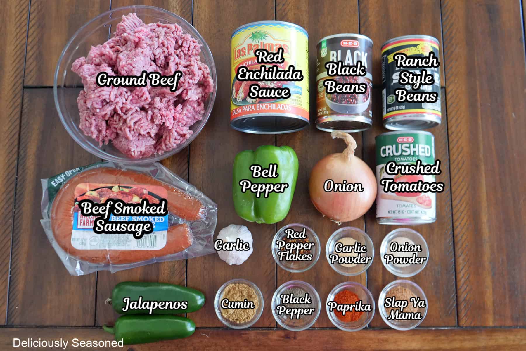 A brown wood tabletop with all the ingredients on it to make a one pot chili.