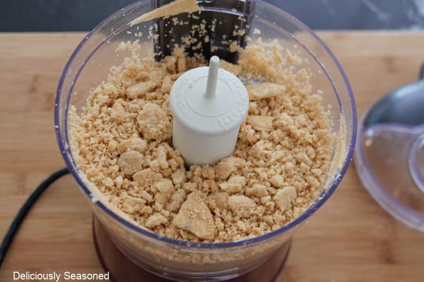 A mini chopper with golden Oreo cookies in it about to be chopped into crumbles.