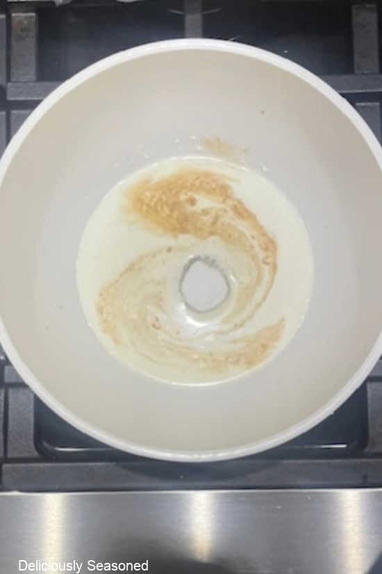 A white bowl with all the ingredients in it to make homemade whipped cream.