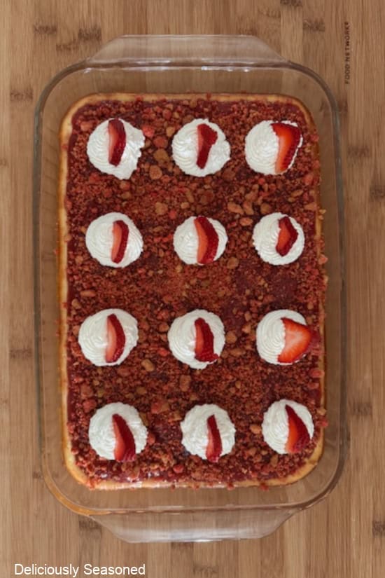 A glass 9x13 baking dish with strawberry cheesecake bars in it before it is sliced into servings.
