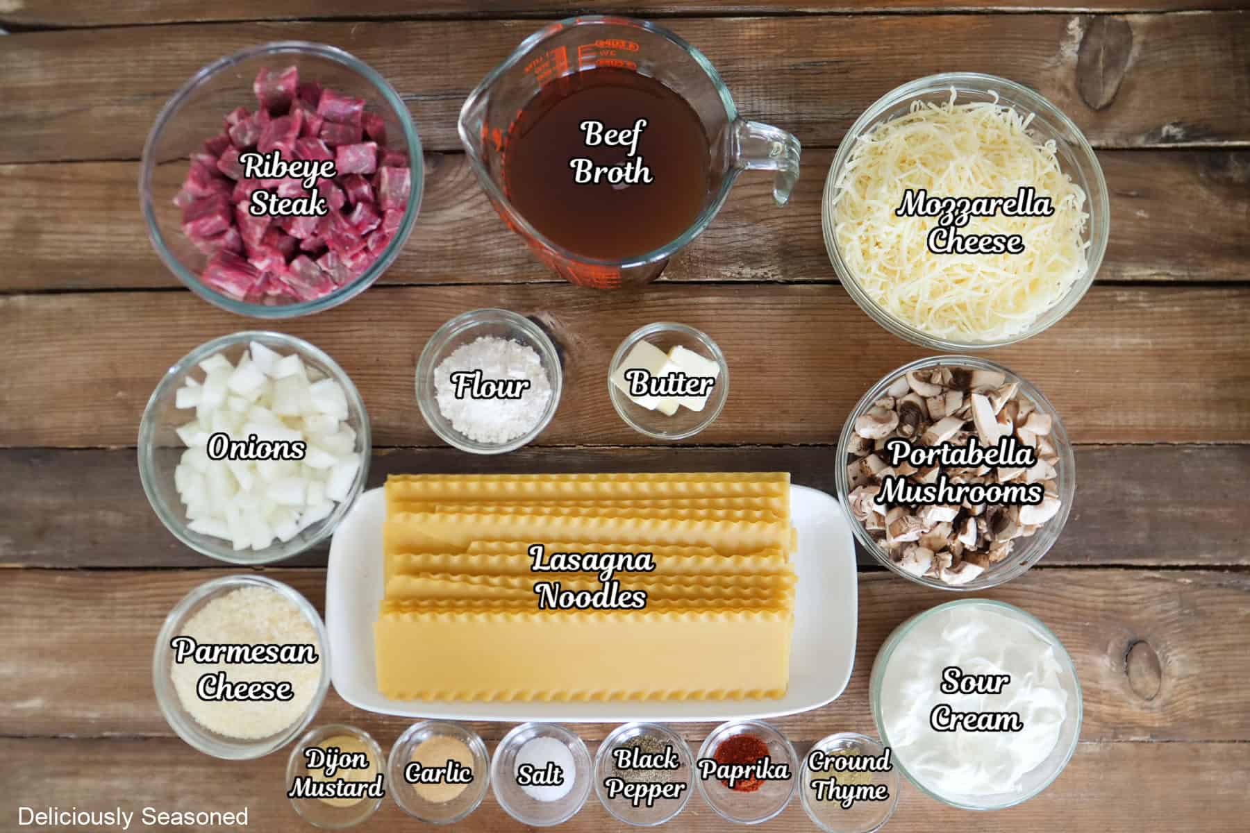 A wood surface with all the ingredients placed on it to make beef stroganoff lasagna.