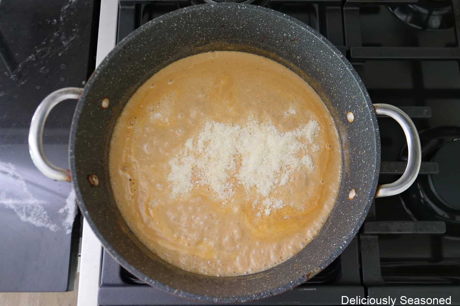 A pan with Parmesan cheese added to the stroganoff sauce before being stirred into the sauce.