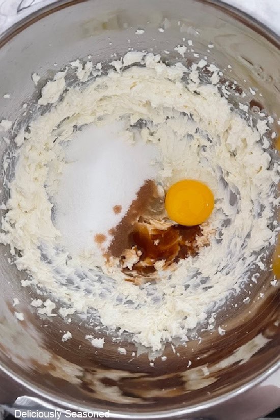 A mixing bowl with all the ingredients in it to make the cream cheese filling before being mixed together.