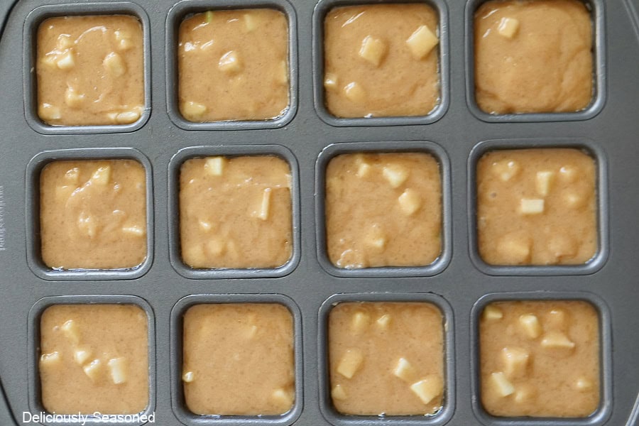A 12-count brownie tin with the blondie batter in each section before going into the oven.