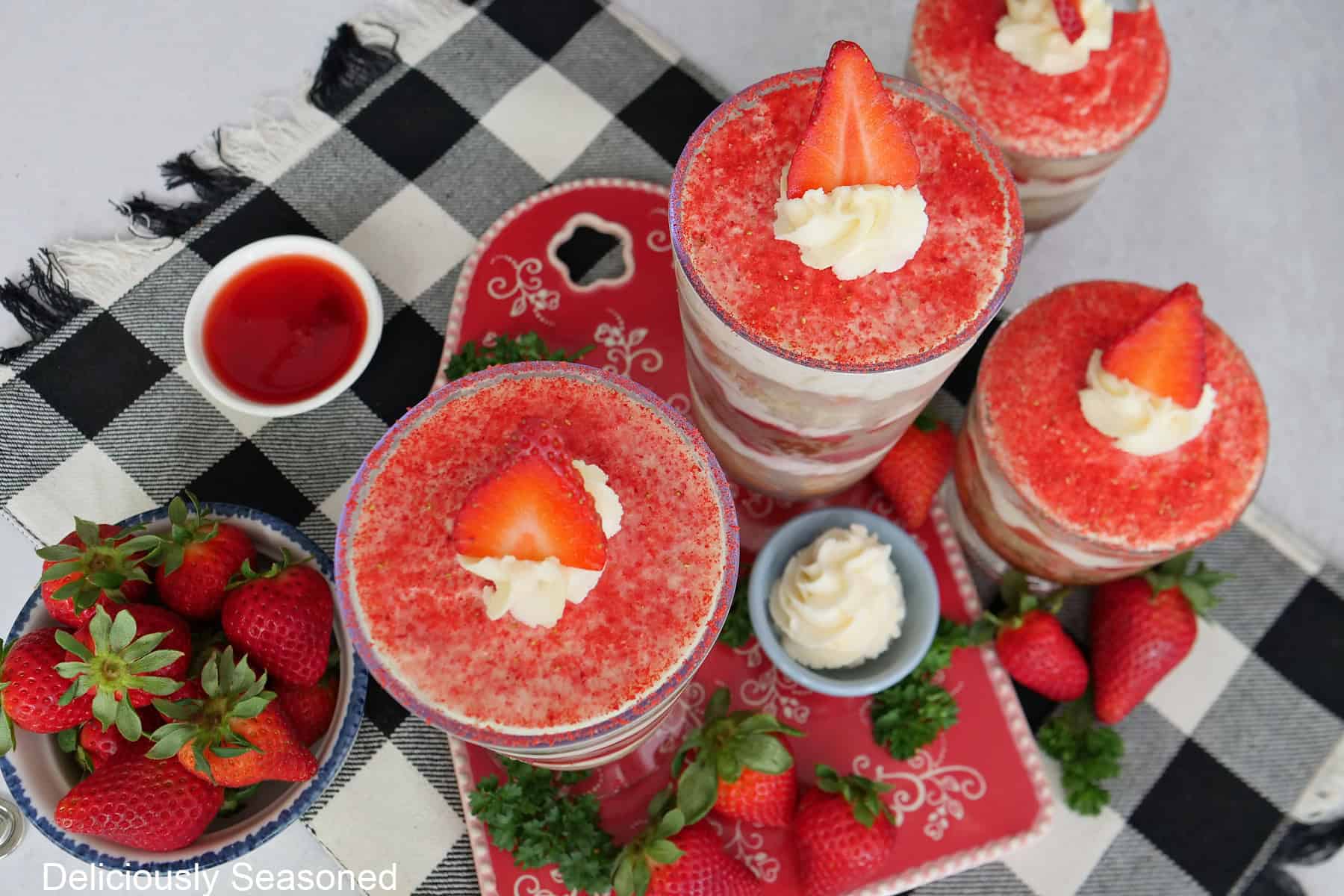 A black and white checked placemat with four parfaits placed on it showing the powdered freeze-dried strawberry topping.