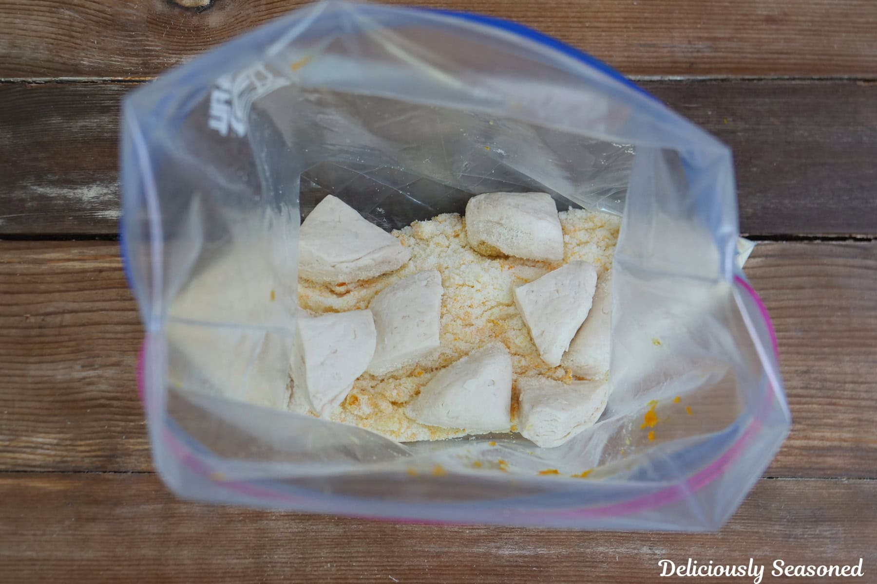 A big baggie with sugar, orange zest, and pieces of biscuits in it.