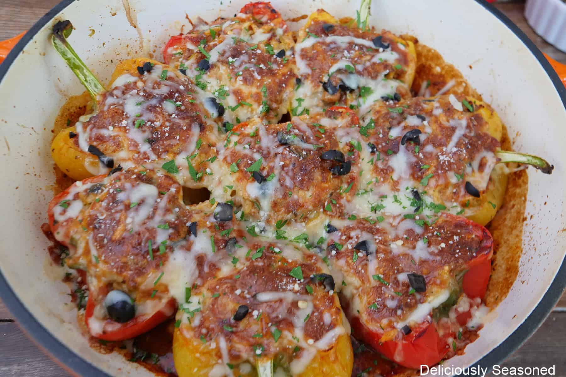 A cast iron skillet with baked pepperoni pizza stuffed peppers in it.