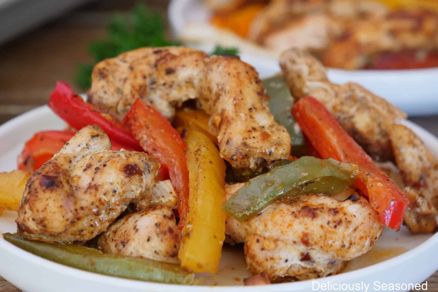 A white plate with a serving of chicken fajitas on it.