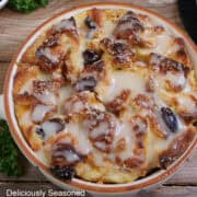 A round baking dish with white chocolate cranberry bread pudding in it after being baked.