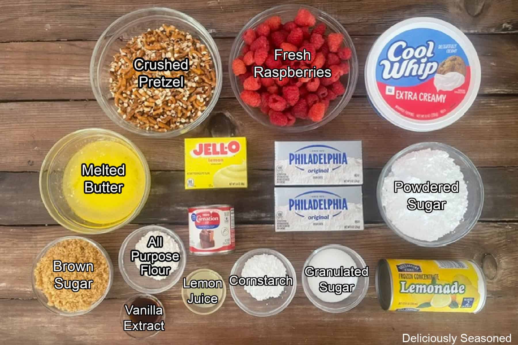 A wood surface with all the ingredients placed on it to make lemon raspberry pretzel salad.