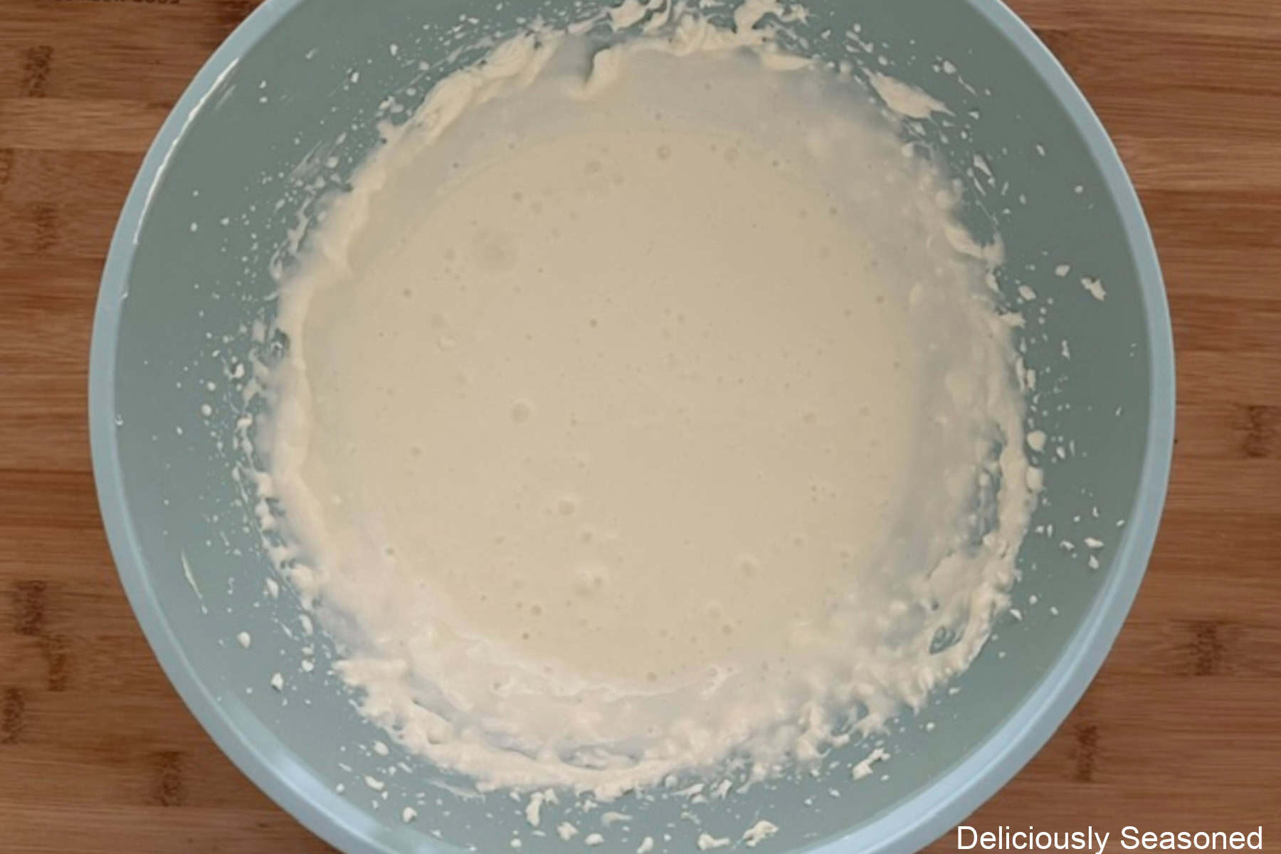 A wood surface with cream cheese beaten until smooth in it.