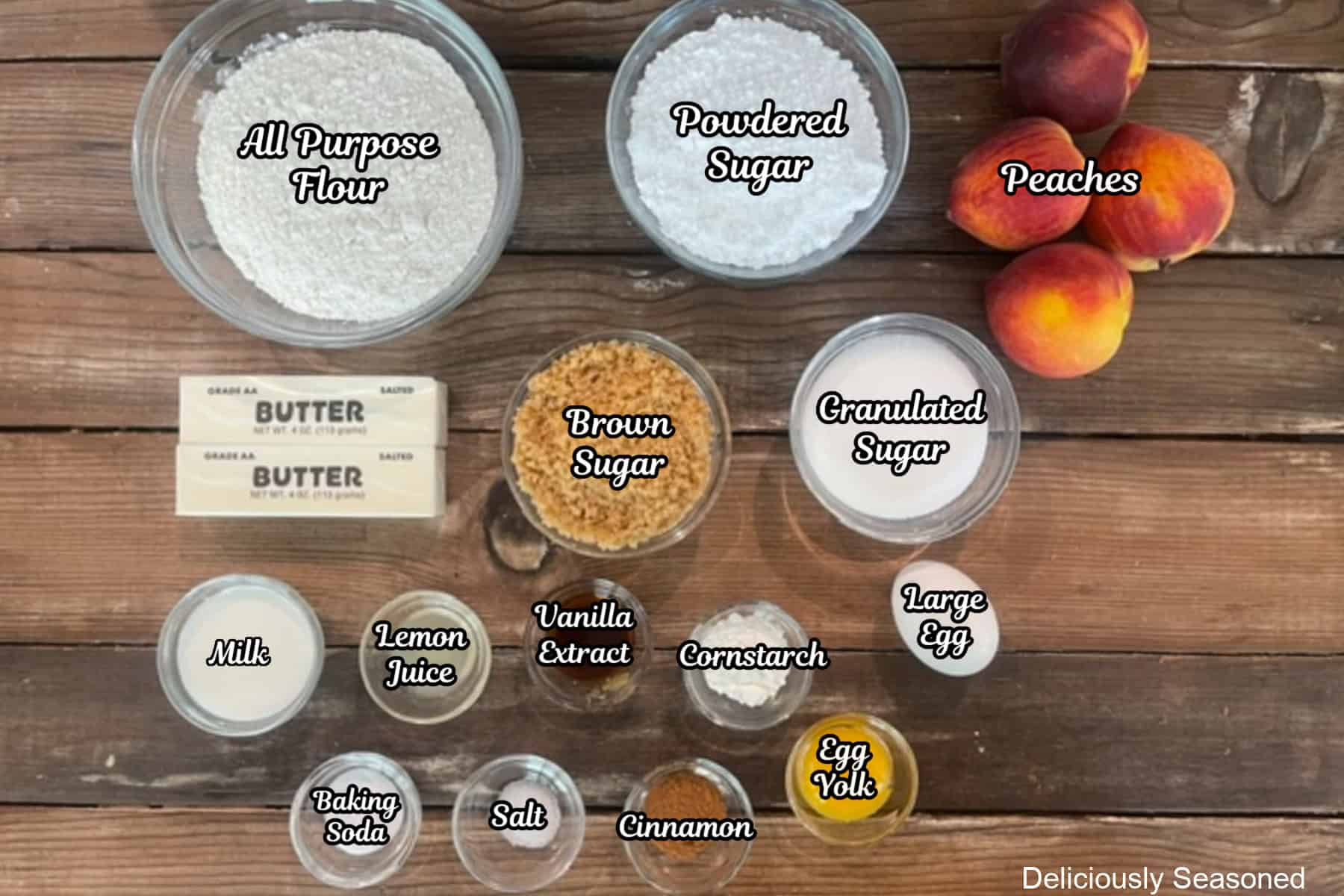 A rustic wood surface with all the ingredients placed on it to make peach cobbler brown butter snickerdoodles.