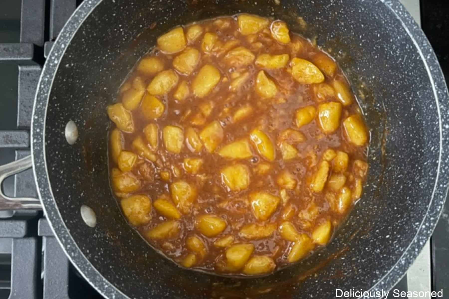 A saucepan with the cooked peach filling in it.