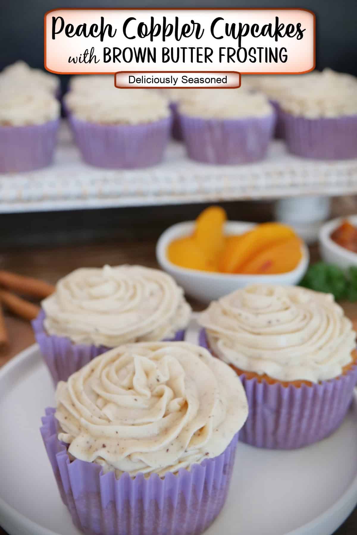 A white plate with four peach cobbler cupcakes on it with a small white bowl of peaches in the background along with more cupcakes on a white tray, and a title overlay at the top.