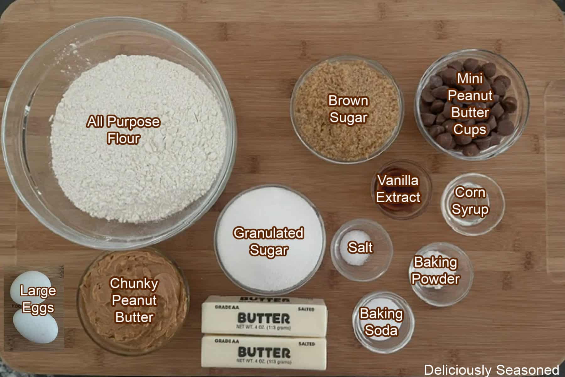 A wood surface with all the ingredients placed on it to make peanut butter cup cookies.