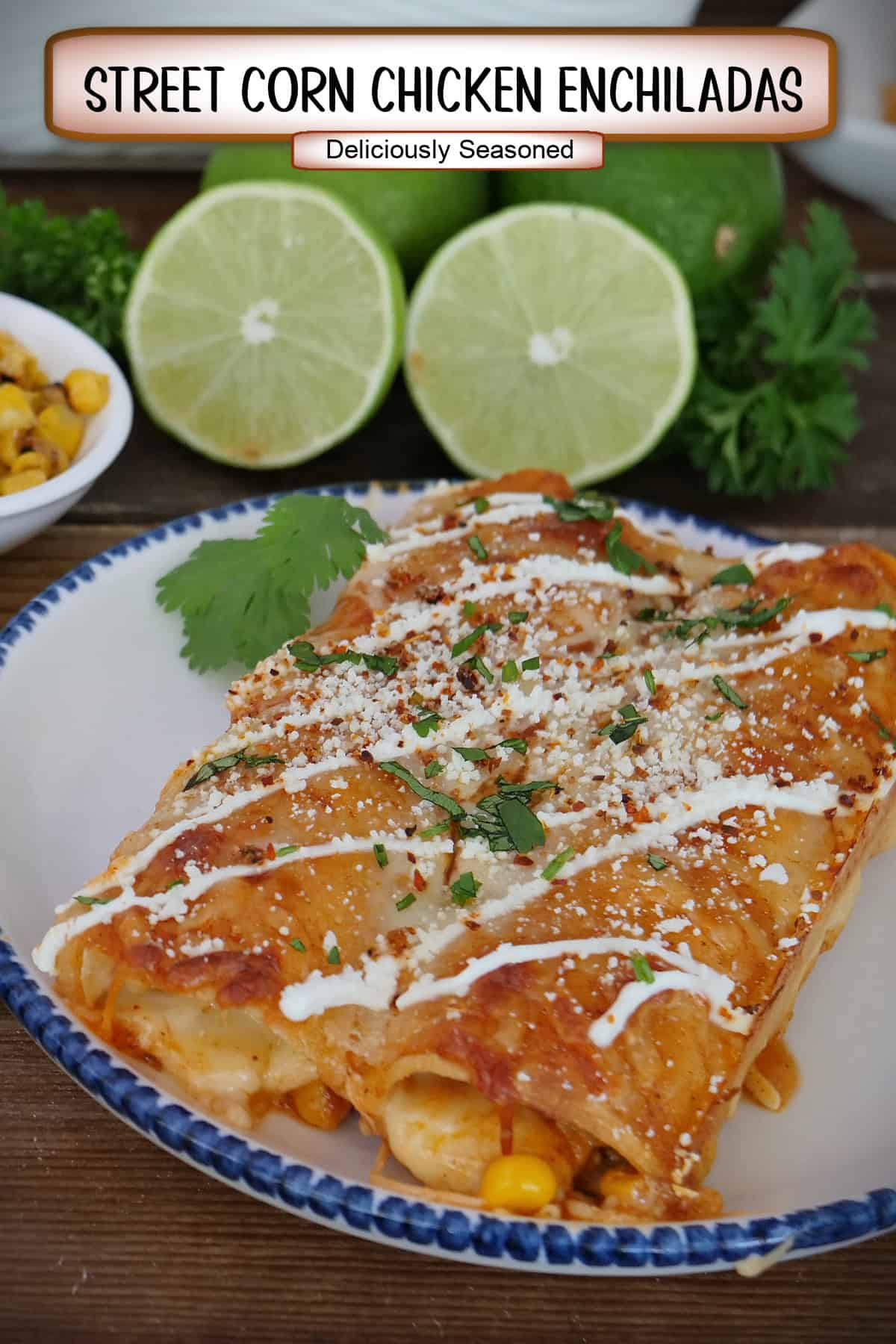 A round white plate with blue trim with two street corn chicken enchiladas on it with to limes cut in half in the background, and a title overlay at the top.