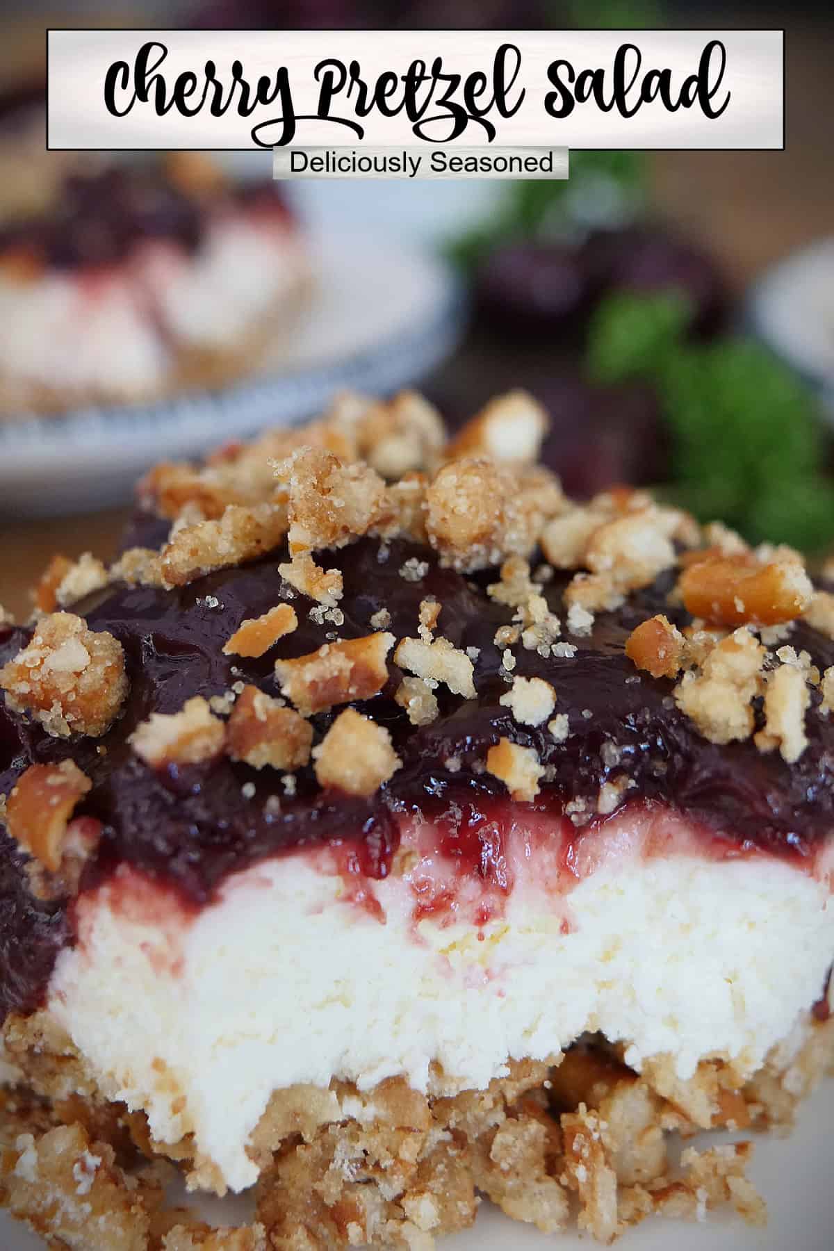 A serving of cherry pretzel salad on a white plate with a title overlay at the top.