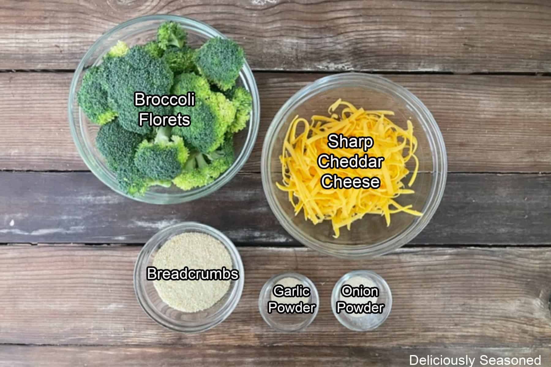A rustic wood surface with five ingredients placed on it to make broccoli cheddar fritters.