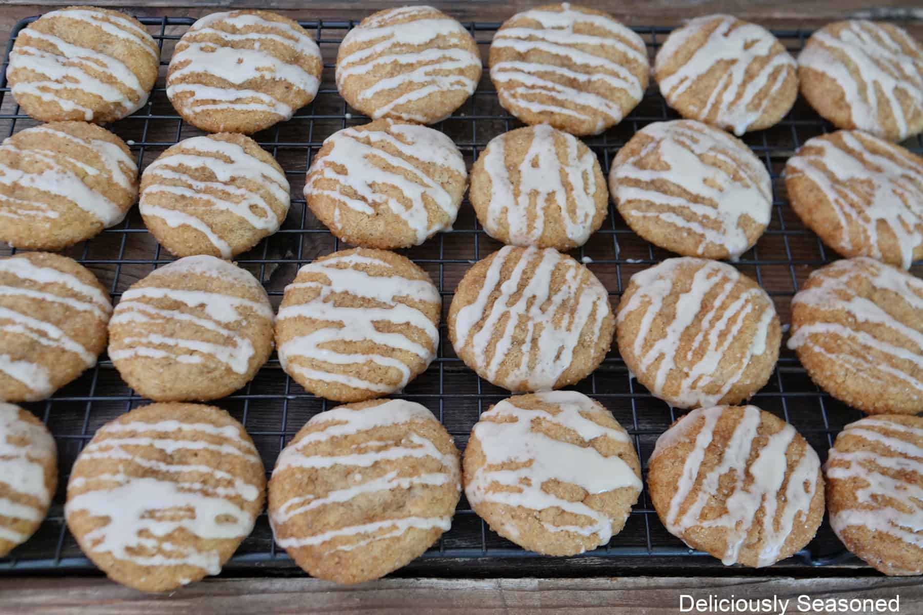 A wire rack with 24 brown butter snickerdoodle cookies on it.