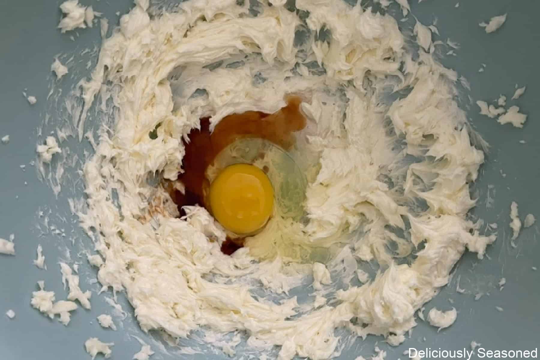 A mixing bowl with the wet ingredients in the sugar cookie batter before being mixed together.