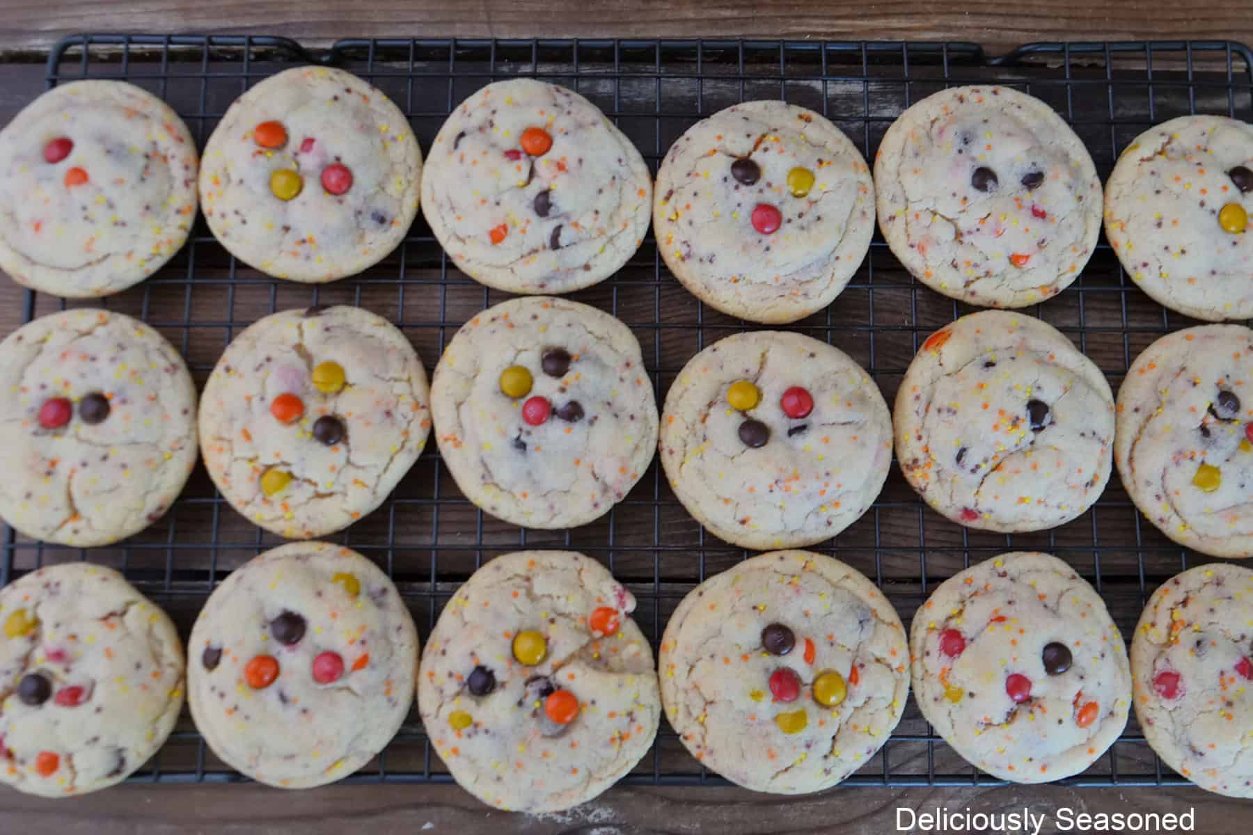 A wire rack with eighteen fall sugar cookies on it cooling.