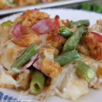 A white plate with blue trim filled with a serving of sheet pan chicken cordon bleu with stuffing.