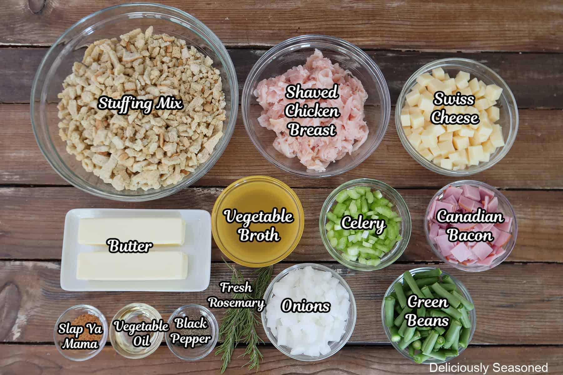A rood surface with all the ingredients placed on it to make sheet pan chicken cordon bleu with stuffing.