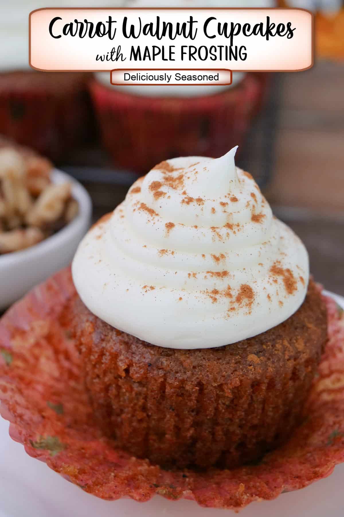 A carrot walnut cupcake with maple frosting on a white plate with a title overlay at the top.