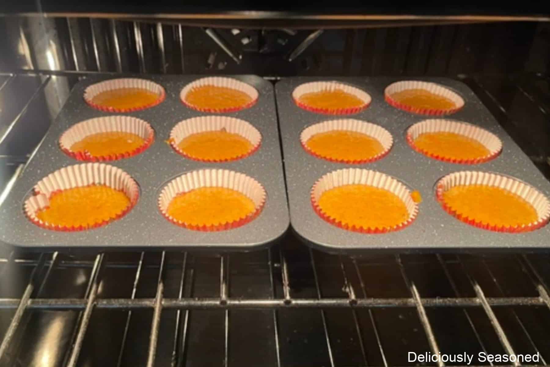 Twelve carrot walnut cupcakes baking in the oven.